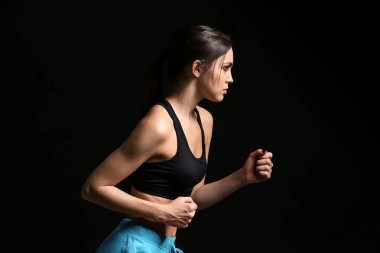 Koyu arka plan üzerinde sportif kadın runner