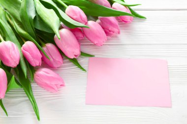 Buket güzel laleler ve Beyaz ahşap zemin üzerinde boş kartı