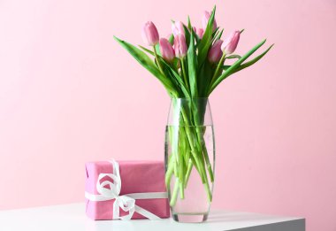 Güzel laleler ve hediye kutusu tablo üzerinde oluşan vazo