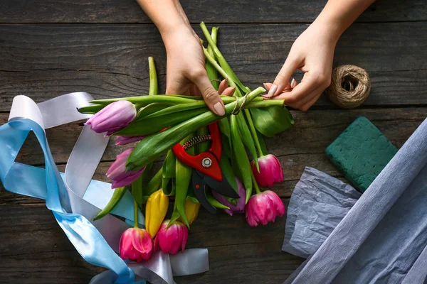 Female florist making beautiful bouquet at workplace