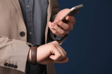 Renk arka planda, closeup bakarak telefon ile şık genç adam