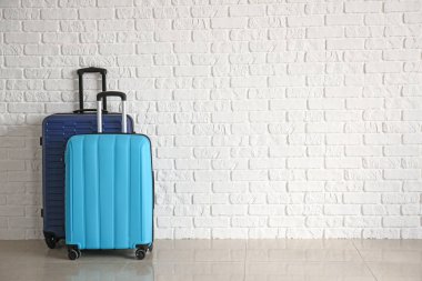Beyaz tuğla duvar yakınındaki dolu bavul
