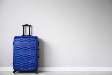 Işık duvarının yanında paketlenmiş bavul