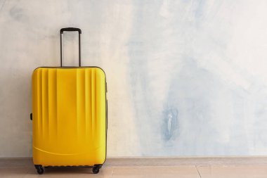 Işık duvarının yanında paketlenmiş bavul