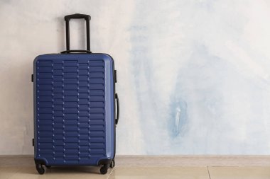 Işık duvarının yanında paketlenmiş bavul