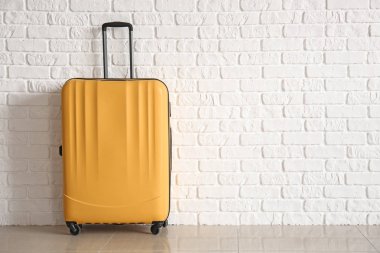 Bavul beyaz tuğla duvar yakınındaki Paketli