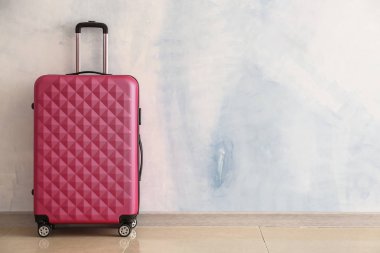 Işık duvarının yanında paketlenmiş bavul