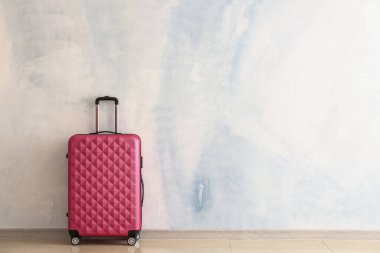 Işık duvarının yanında paketlenmiş bavul