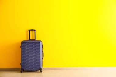 Renkli duvarın yanında paketlenmiş bavul