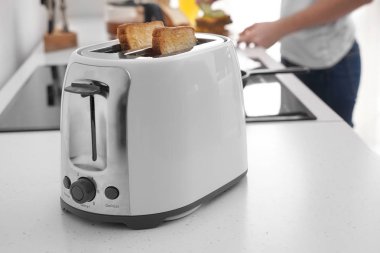 Mutfak masasında ekmek dilimleri olan tost makinesi.