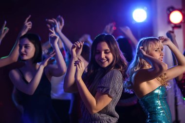 Gece kulübünde dans eden güzel genç kadınlar.