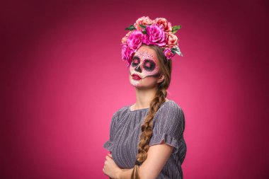 Meksika Ölüler Günü için yüzünde boyalı kafatası olan genç bir kadın.