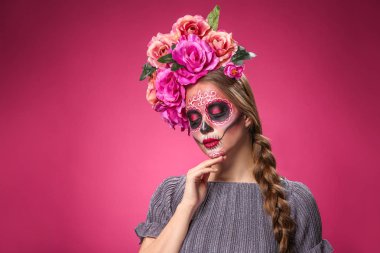 Meksika Ölüler Günü için yüzünde boyalı kafatası olan genç bir kadın.