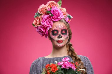Meksika Ölüler Günü için yüzünde boyalı kafatası olan genç bir kadın.