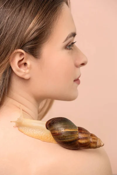 在颜色背景上的巨型 Achatina 蜗牛的年轻妇女 — 图库照片