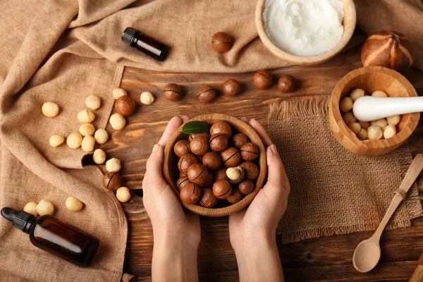 Female Hands Macadamia Nuts Natural Cosmetics Wooden Background — Stock Photo, Image