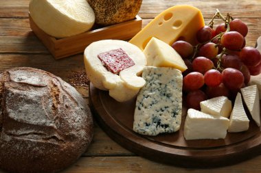 Lezzetli peynir ve ekmek tablosundaki ürün yelpazesine ahşap tahta