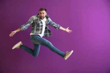 Renkli arka planda zıplayan genç adam