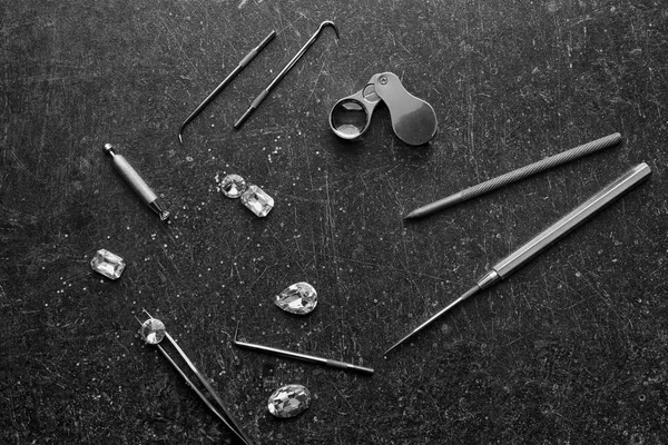 Precious stones and jeweler's tools on grey background — Stock Photo, Image