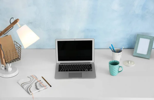 Modern laptop on light table near white color wall — Stock Photo, Image