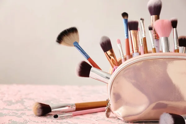 Set of makeup brushes in cosmetic bag on table — Stock Photo, Image