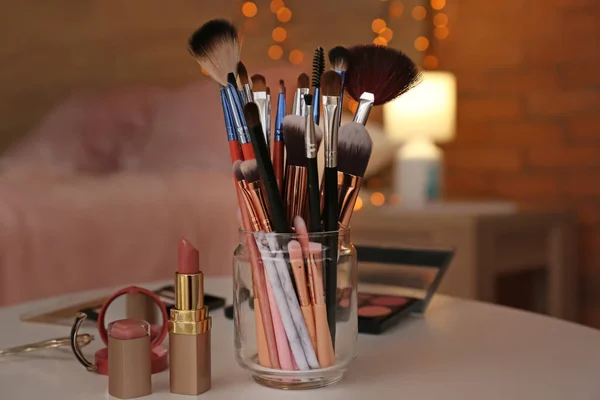 Conjunto de pinceles de maquillaje y cosméticos sobre mesa — Foto de Stock