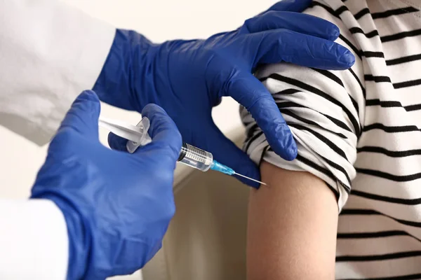 Läkare vaccinerande barn mot influensa i klinik — Stockfoto
