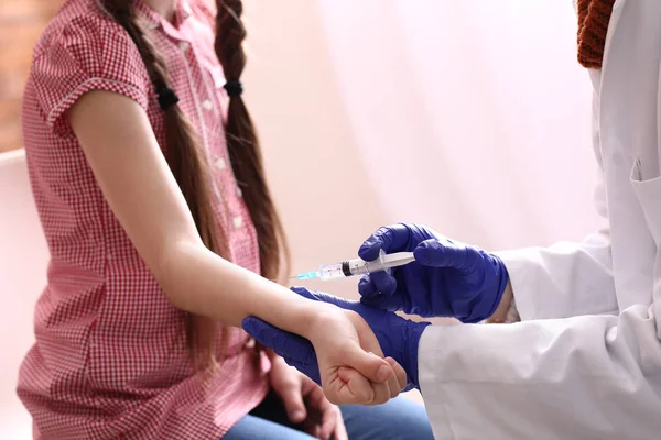 Лікар щеплює дитину від грипу в клініці — стокове фото