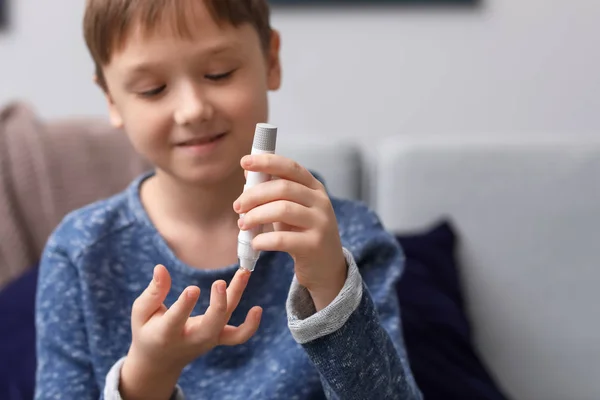 Enfant diabétique prélevant un échantillon de sang avec un stylo lancette à la maison — Photo