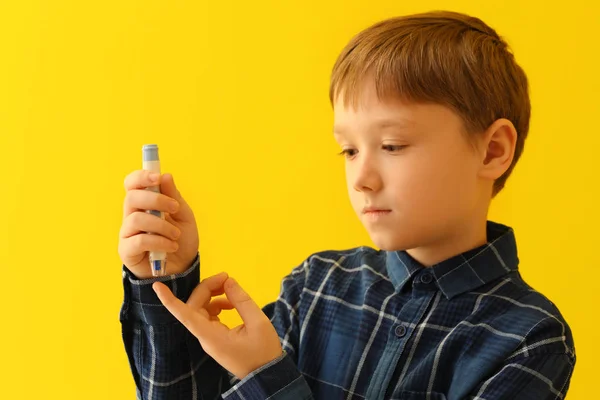 Diabetické dítě užívající vzorku krve lomený perem na barvu pozadí — Stock fotografie