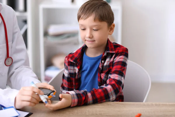 Medico che preleva campioni di sangue di bambino diabetico in clinica — Foto Stock