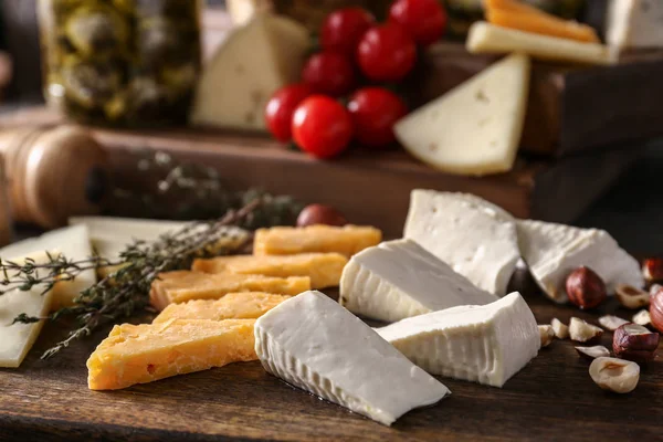 Assortment of tasty cheese on wooden board — Stock Photo, Image