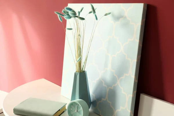Vase with picture on table near color wall — Stock Photo, Image