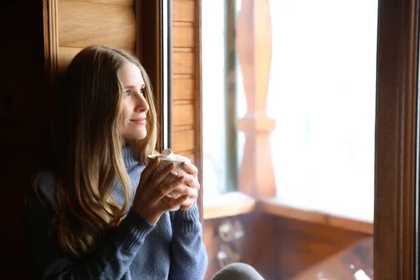 Woman drinking hot cacao near window in morning — Stock Photo, Image