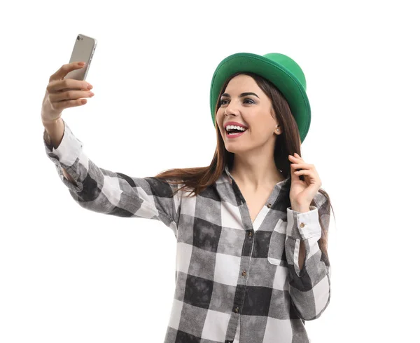 Mulher bonita em chapéu verde tomando selfie no fundo branco. Celebração do Dia de São Patrício — Fotografia de Stock