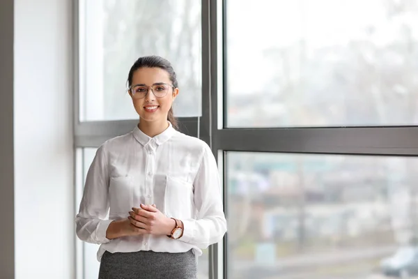 Portret van een jonge zakenvrouw in de buurt van een raam in het kantoor — Stockfoto