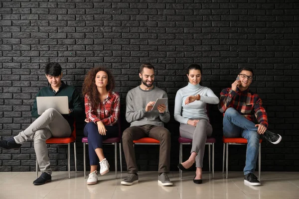 Jóvenes esperando entrevista de trabajo en interiores —  Fotos de Stock