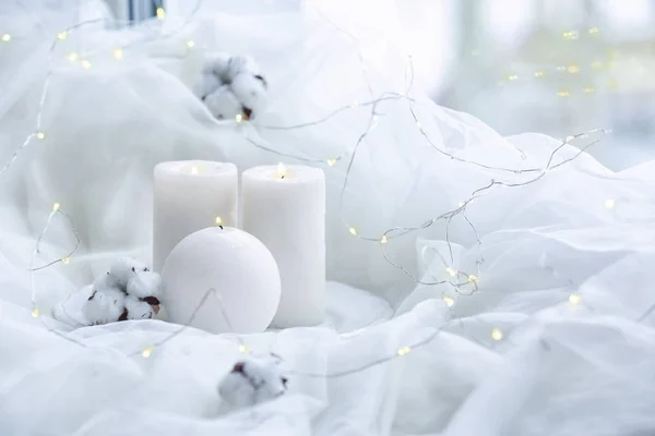 Mooie brandende kaarsen met katoen bloemen op witte stof — Stockfoto