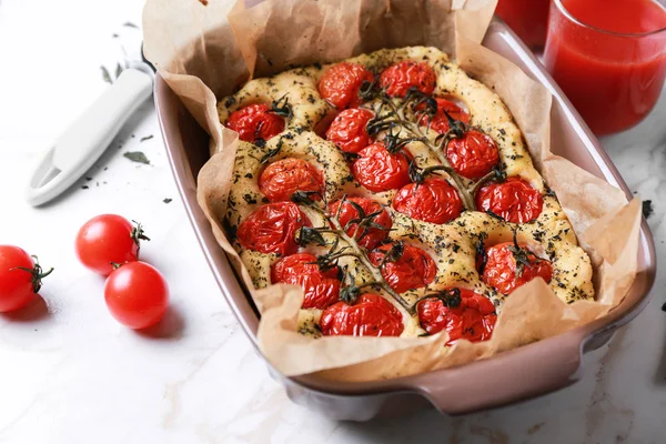 Baking dish with tasty Italian focaccia on light table — Stock Photo, Image