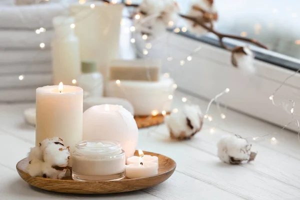 Beautiful burning candles with jar of cream on windowsill — Stock Photo, Image