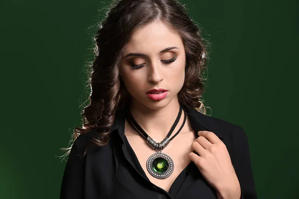 Mujer joven con hermosas joyas sobre fondo de color oscuro —  Fotos de Stock