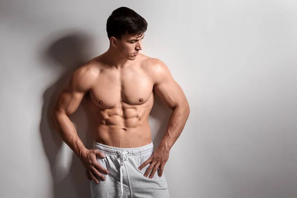 Gespierde bodybuilder op lichte achtergrond — Stockfoto