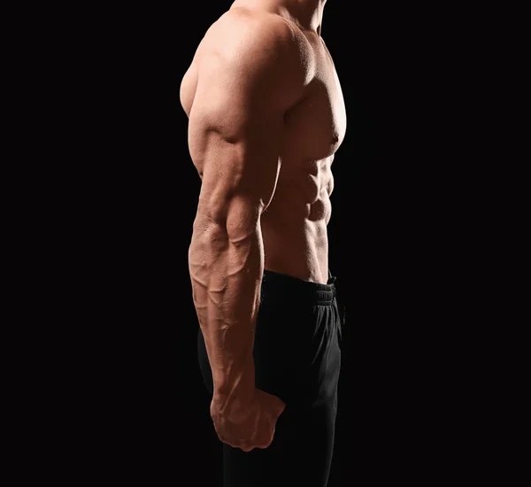 Muscular fisiculturista em fundo escuro — Fotografia de Stock