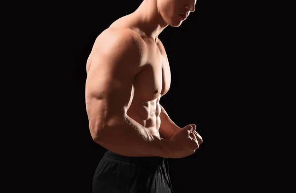 Muscular bodybuilder on dark background — Stock Photo, Image
