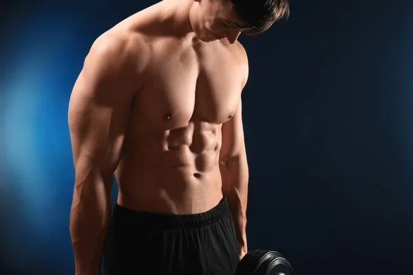 Muskulös bodybuilder med hantel på mörk bakgrund — Stockfoto
