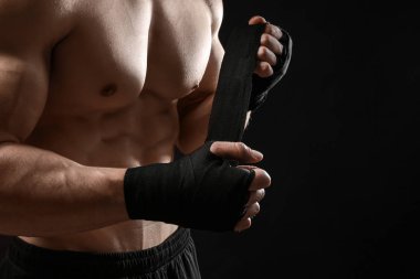 Bilek band koyu arka plan karşı sarma çekici sporcu