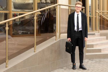 Caddenin üzerinde şık evrak çantası ile yakışıklı işadamı