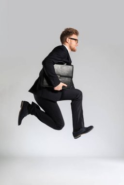 İşadamı ile şık çanta ışık arka plan üzerinde atlama