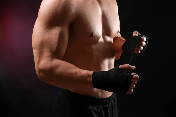 Attraktiva sportsman slingrande armband mot mörk bakgrund — Stockfoto