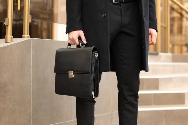 Businessman with stylish briefcase on city street